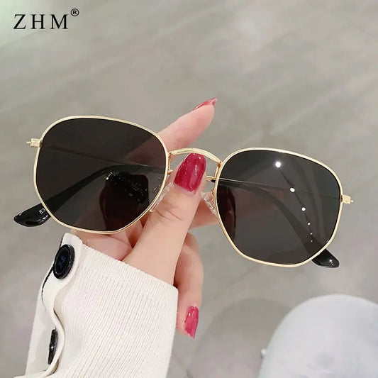 Holding gold frame with  grey black lenses