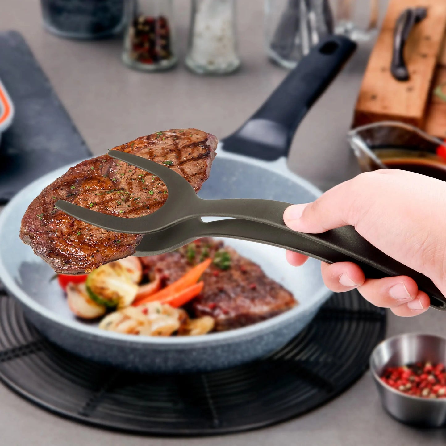 Tongs holding a steak